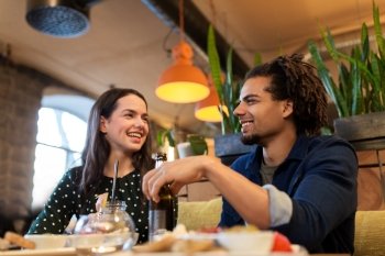 leisure, eating, food and drinks, people and holidays concept - happy couple with drinks at cafe or bar