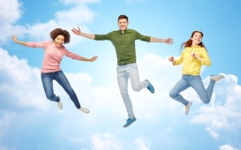 happiness, freedom, motion and people concept - smiling young man jumping in air over blue sky and clouds background