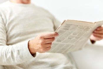 information, people and mass media concept - close up of senior man reading newspaper