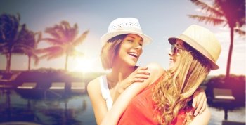 summer holidays, vacation, travel and people concept - smiling young women in hats and casual clothes on beach