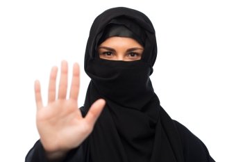 gesture, religious prohibition and people concept - muslim woman in hijab showing stop sign over white background. muslim woman in hijab showing stop sign