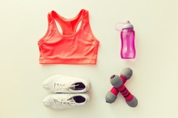 sport, fitness, healthy lifestyle and objects concept - close up of female sports clothing, dumbbells and bottle set. close up of sportswear, dumbbells and bottle