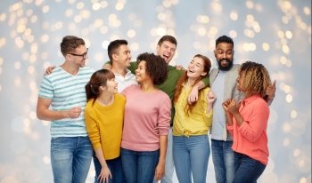 diversity, race, ethnicity and people concept - international group of happy men and women laughing over holidays lights background. international group of happy laughing people