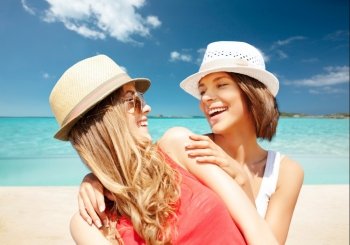 summer holidays, travel, people and vacation concept - happy young women in hats over exotic tropical beach background. happy young women in hats on summer beach