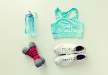 sport, fitness, healthy lifestyle and objects concept - close up of female sports clothing, dumbbells and bottle set. close up of sportswear, dumbbells and bottle