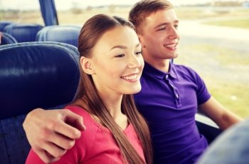 transport, tourism, road trip and people concept - happy teenage couple or tourists hugging in travel bus. happy teenage couple or passengers in travel bus
