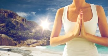 fitness, sport and people concept - close up of woman doing yoga over exotic tropical beach background. close up of woman doing yoga on beach