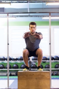 fitness, sport, training, exercising and people concept -young man doing box jumps exercise in gym. young man doing box jumps exercise in gym
