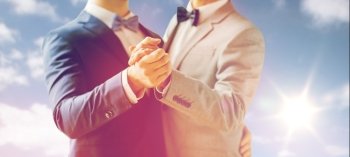 people, homosexuality, same-sex marriage and love concept - close up of happy male gay couple holding hands and dancing on wedding over sky and sun background. close up of happy male gay couple dancing