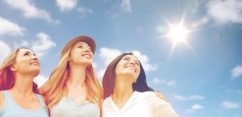 summer holidays, friendship and people concept - group of happy smiling women or friends over sky and sun background. group of happy smiling women or friends over sky