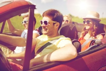 leisure, road trip, travel and people concept - happy friends driving in cabriolet car along country road. happy friends driving in cabriolet car