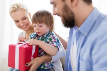 people and holidays concept - happy family with birthday gift at home. happy family with birthday gift at home