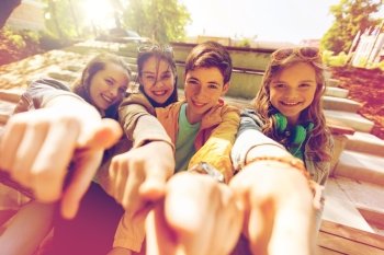 friendship, gesture and people concept - happy teenage friends or high school students pointing finger at you. teenage friends or students pointing finger at you
