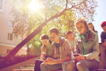 technology, internet addiction and people concept - group of teenage friends or high school students with smartphones outdoors. group of teenage friends with smartphones outdoors