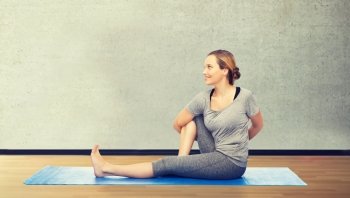 fitness, sport, people and healthy lifestyle concept - woman making yoga in twist pose on mat over room or gym background. woman making yoga in twist pose on mat