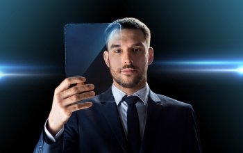 business, augmented reality and future technology concept - businessman in suit working with transparent tablet pc computer over black background. businessman working with transparent tablet pc