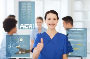 medicine, healthcare, technology and people concept - happy female doctor or nurse over group of medics meeting at hospital showing thumbs up gesture. happy smiling doctor showing thumbs up at hospital