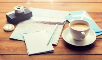 vacation, tourism, travel and objects concept - close up of blank notepad with map, coffee and airplane tickets. close up of notepad with map and travel tickets