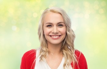 fashion, portrait and people concept - happy smiling young woman in red cardigan over green background with lights. happy smiling young woman in red cardigan