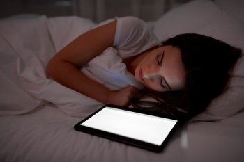 technology and people concept - young woman with tablet pc computer sleeping in bed at home at night. woman with tablet pc sleeping in bed at night