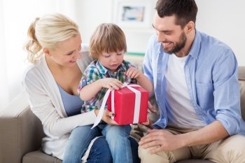 people and holidays concept - happy family with birthday gift at home. happy family with birthday gift at home. happy family with birthday gift at home