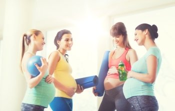 pregnancy, sport, fitness, people and healthy lifestyle concept - group of happy pregnant women with sports equipment talking in gym. group of happy pregnant women talking in gym. group of happy pregnant women talking in gym