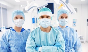 surgery, medicine and people concept - group of surgeons in operating room at hospital. group of surgeons in operating room at hospital. group of surgeons in operating room at hospital