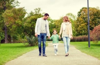 family, parenthood, adoption and people concept - happy mother, father and little girl walking in summer park. happy family walking in summer park. happy family walking in summer park