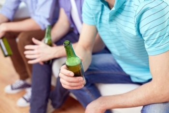 alcohol and people concept - men with beer bottles sitting on sofa at home. men with beer bottles sitting on sofa at home. men with beer bottles sitting on sofa at home