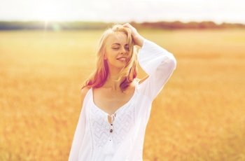 country, nature, summer holidays, vacation and people concept - smiling young woman in white dress on cereal field. smiling young woman in white dress on cereal field. smiling young woman in white dress on cereal field