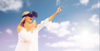 augmented reality, gaming, technology and people concept - amazed young woman with virtual reality headset or 3d glasses pointing finger to something outdoors. amazed woman in virtual reality headset . amazed woman in virtual reality headset 