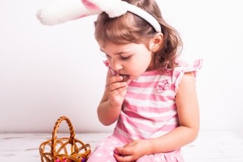 Girl eats a chocolate little eggs after Easter hunting. Girl eats a chocolate eggs