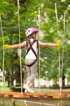 Kids on obstacle course in adventure park in mountain helmet and safety equipment. The obstacle course in adventure park 