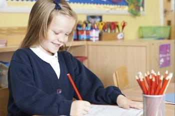 Female Elementary School Pupil Working At Desk