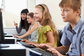 Elementary Pupils In Computer Class With Teacher