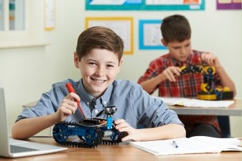 Two Male Pupils In Science Lesson Studying Robotics