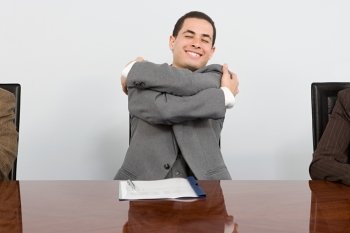 Businessman hugging himself