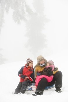 Father and kids having warm drink in snow