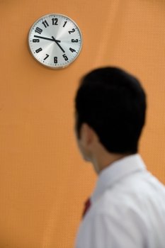 Office worker looking at a wall clock