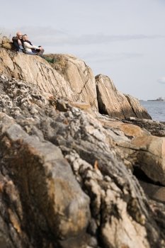 Mature couple resting on rocks
