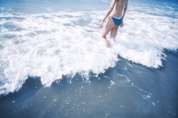Woman walking into waves at the beach