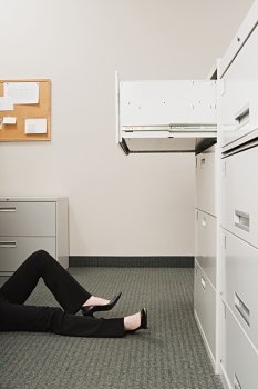 Woman lying by filing cabinet