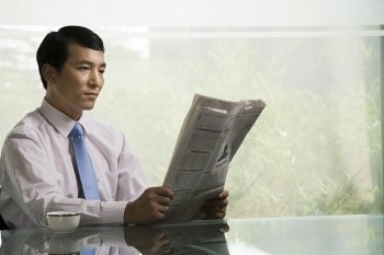 Chinese businessman reading a newspaper