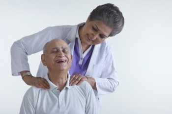 Doctor massaging old mans shoulders
