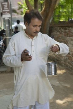 Man looking into a milk canister