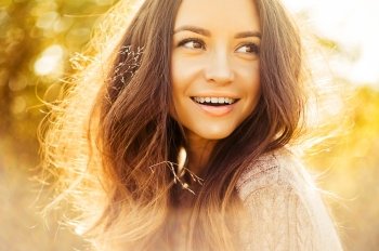 Outdoor atmospheric lifestyle photo of young beautiful lady. Brown hair and eyes. Warm autumn. Warm spring