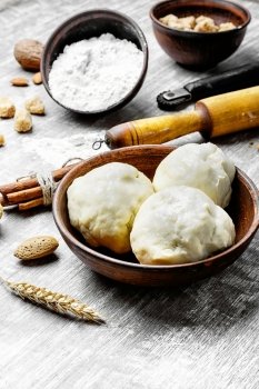 dough with flour and rolling pin. preparing bread dough and baking ingredients on light background