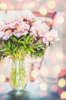 Lovely  pink peonies flowers bunch in vase at sunshine bokeh background
