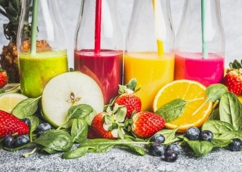 Various colorful beverage in bottles with fresh organic ingredients .Healthy smoothies or juice with fresh fruits, berries and vegetables, front view