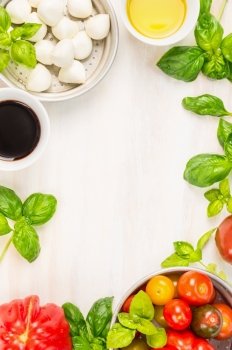 caprese salad ingredients on white wooden background, top view, place for text, italian food frame